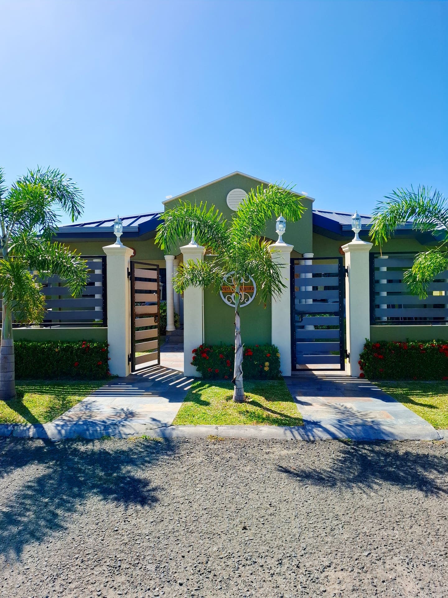 Sugar Haven Villas gated entrance with palm tree and driveway